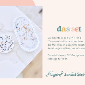 May include: A white oval tray and a round coaster with terrazzo-style patterns in blue, orange, and black. The text "das set" is displayed in teal, and the text "Fragen? kontaktiere uns!" is in green.