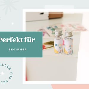 May include: Two small glass bottles with silver lids and labels. The labels have text and colourful accents. The image also includes a teal box with the words "Perfekt f&uuml;r" and "Beginner".