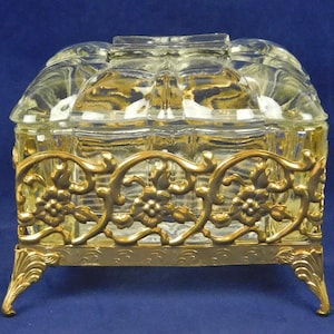 Vintage Hollywood Regency Style Clear Glass Lidded Trinket Vanity Dresser Desk Dish with Gold Ornate Floral Footed Gold Tone Metal Base