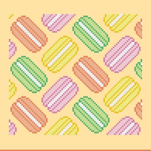 Op de afbeelding: Een patroon van kleurrijke macarons op een gele achtergrond. De macarons zijn in tinten roze, groen, geel en oranje.