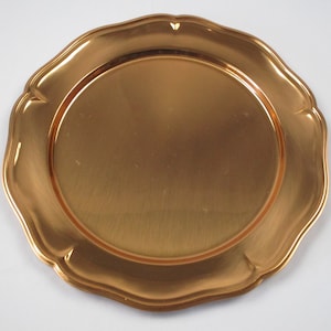 May include: A gold charger plate with a scalloped edge.