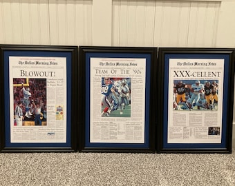 Puede incluir: Tres páginas enmarcadas del periódico Dallas Morning News. Los titulares son "BLOWOUT!", "TEAM OF THE '90s" y "XXX-CELLENT". Cada marco tiene un borde negro y una esterilla azul. Los artículos presentan acción de partidos de fútbol americano.