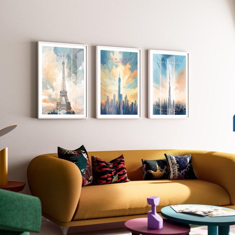 May include: Three framed watercolor paintings of cityscapes. The leftmost painting features the Eiffel Tower in Paris, the middle painting features the New York City skyline, and the rightmost painting features the Burj Khalifa in Dubai.