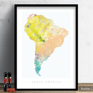 May include: A watercolor print of South America with a yellow, orange, and blue color scheme. The print is framed in a black frame and has the text "SOUTH AMERICA" at the bottom.