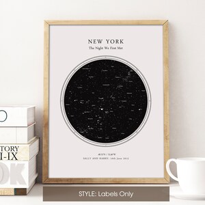 May include: A framed print showing a star map of New York, with the text "The Night We First Met." The print includes coordinates, names, and a date. The frame is light brown, and the print has a black and white colour scheme. The style is labelled "Labels Only."
