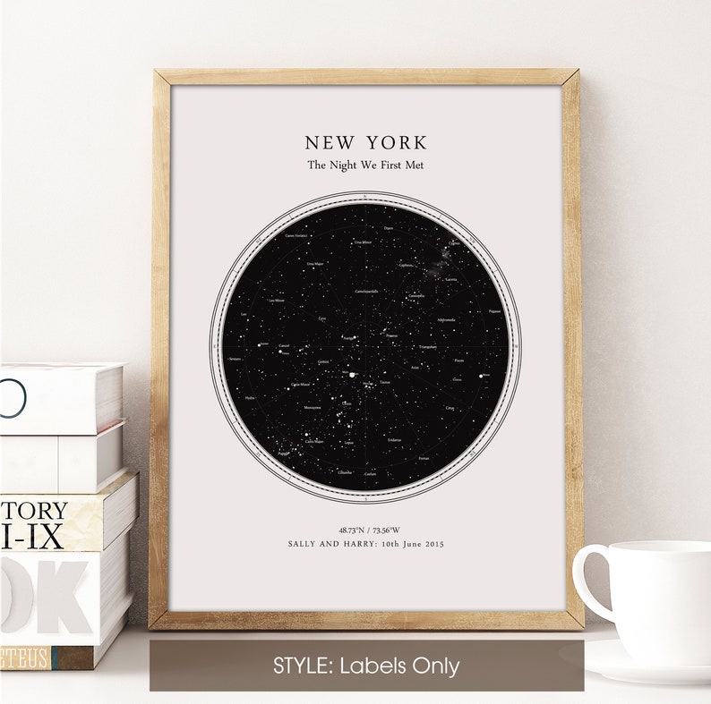 May include: A framed print showing a star map of New York, with the text "The Night We First Met." The print includes coordinates, names, and a date. The frame is light brown, and the print has a black and white colour scheme. The style is labelled "Labels Only."