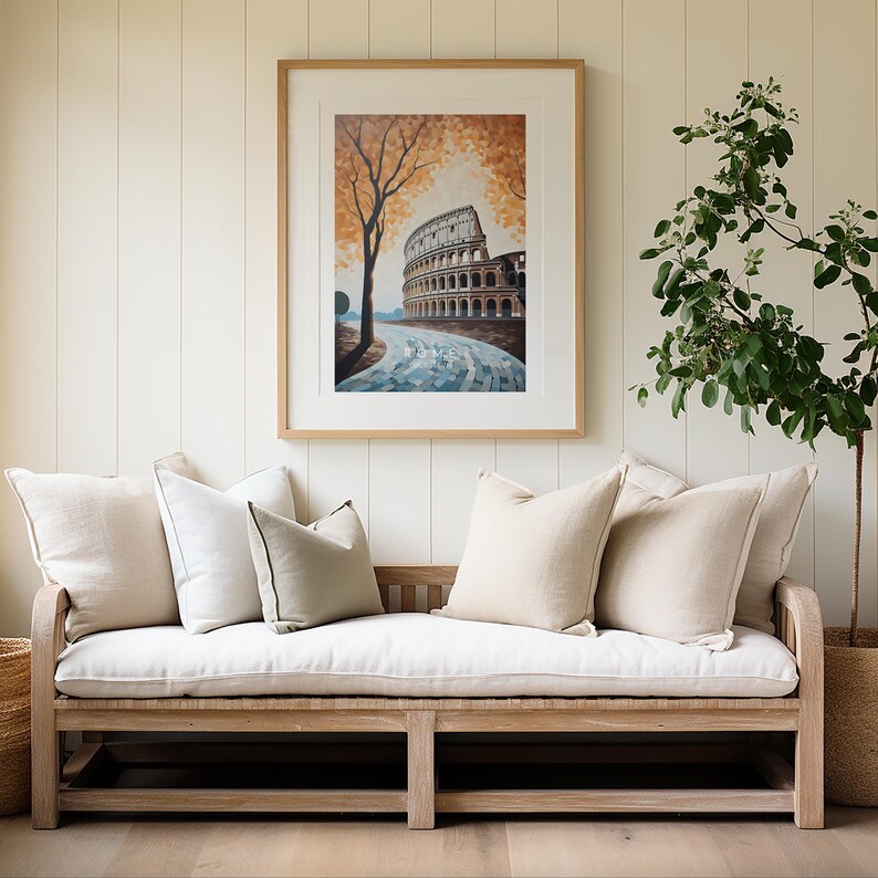 May include: A white linen sofa with a wooden frame and four pillows. The sofa is in front of a white wall with a framed print of the Colosseum in Rome. A green plant is in a pot on the right side of the image.