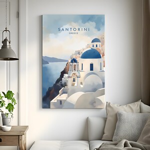 Puede incluir: Un cuadro enmarcado de Santorini, Grecia, con edificios blancos, c&uacute;pulas azules y campanarios en un acantilado con vistas al mar. La impresi&oacute;n tiene el texto "SANTORINI GREECE" en la parte superior.