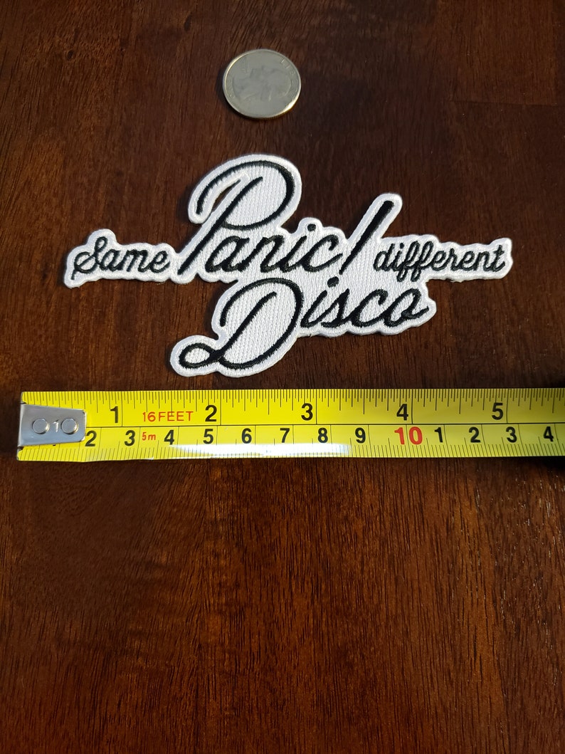 May include: White embroidered patch with black lettering that reads "Same Panic! Different Disco".
