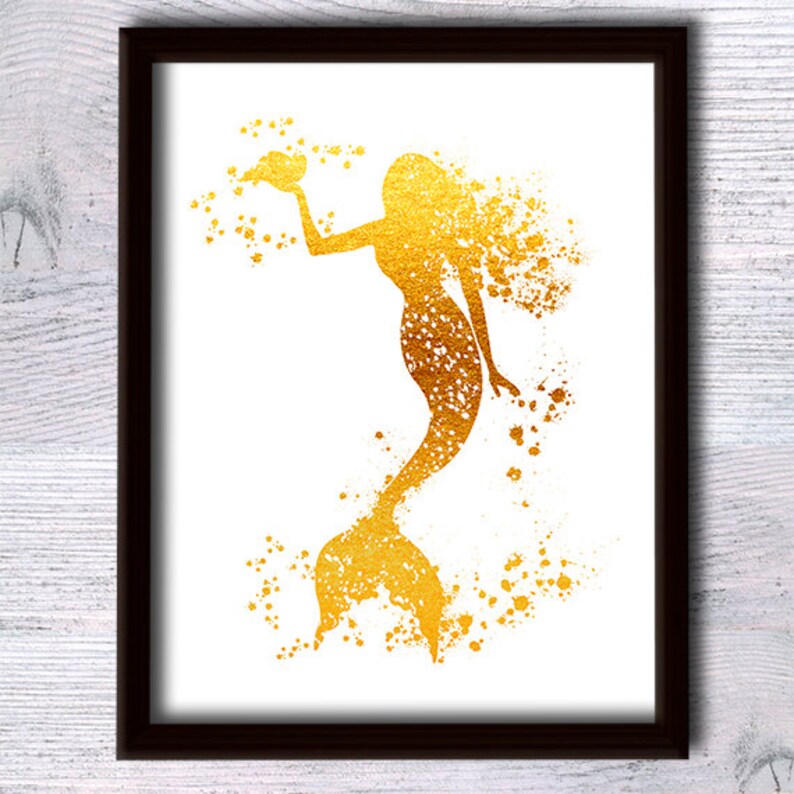 May include: A gold foil mermaid silhouette with a splatter paint effect on a white background.