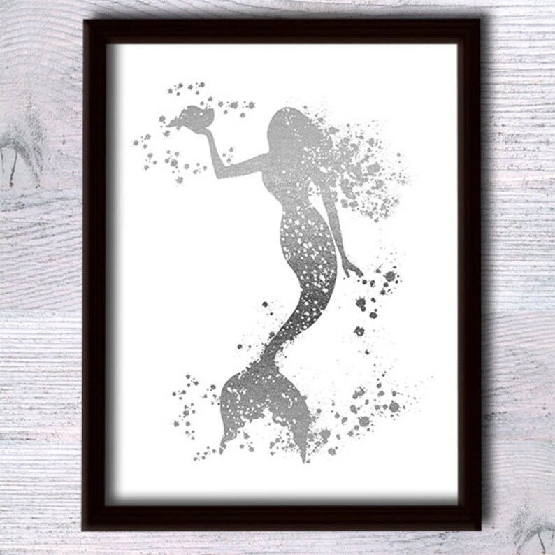 May include: A silver glitter mermaid silhouette with a shell in her hand, surrounded by silver glitter splatters on a white background.