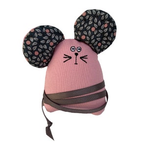 May include: A pink fabric mouse with gray fabric ears featuring a leaf pattern. The mouse has embroidered eyes, a nose, and whiskers.