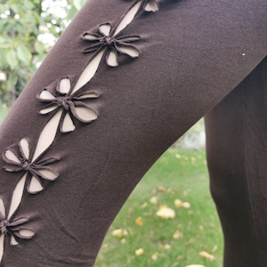 Könnte beinhalten: Braune Leggings mit ausgeschnittenen Blumenmustern entlang der Seitennaht.
