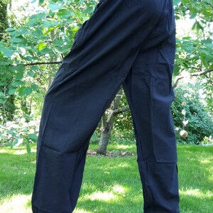 May include: Black cotton pants with a wide leg and a gathered elastic waistband.