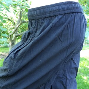 May include: Black cotton pants with a drawstring waistband.