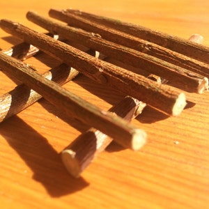 May include: A set of brown wooden sticks arranged in a grid pattern. The sticks are smooth and have a natural finish.