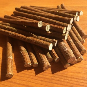 May include: A pile of brown wooden sticks, likely for crafts or model building.