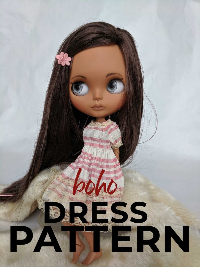 Puede incluir: Una mu&ntilde;eca con un vestido de rayas rosas y blancas con ribete de encaje. El vestido tiene el texto "boho DRESS PATTERN". La mu&ntilde;eca tiene el pelo largo y casta&ntilde;o y los ojos marrones.
