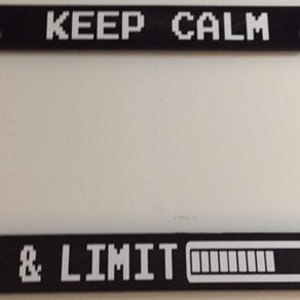 May include: Black license plate frame with white text that reads "KEEP CALM & LIMIT" with a white pixelated bar graph that is almost full.
