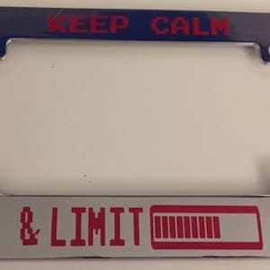 May include: Chrome license plate frame with red text that reads "KEEP CALM & LIMIT" and a red battery icon with a partially filled bar.