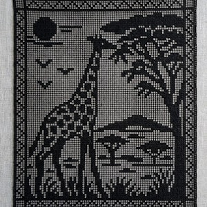Puede incluir: Un panel rectangular de ganchillo filet negro con una escena detallada de una jirafa junto a un árbol grande. El diseño incluye un sol en la esquina superior izquierda, tres aves en vuelo y árboles más pequeños en el paisaje.