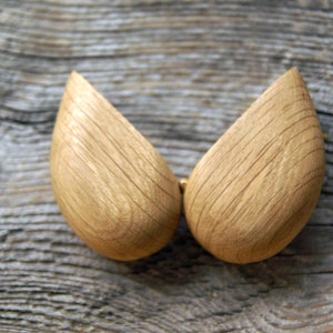 May include: Two wooden halves of a heart-shaped box, with a natural wood grain finish. The box is open and the two halves are separated.