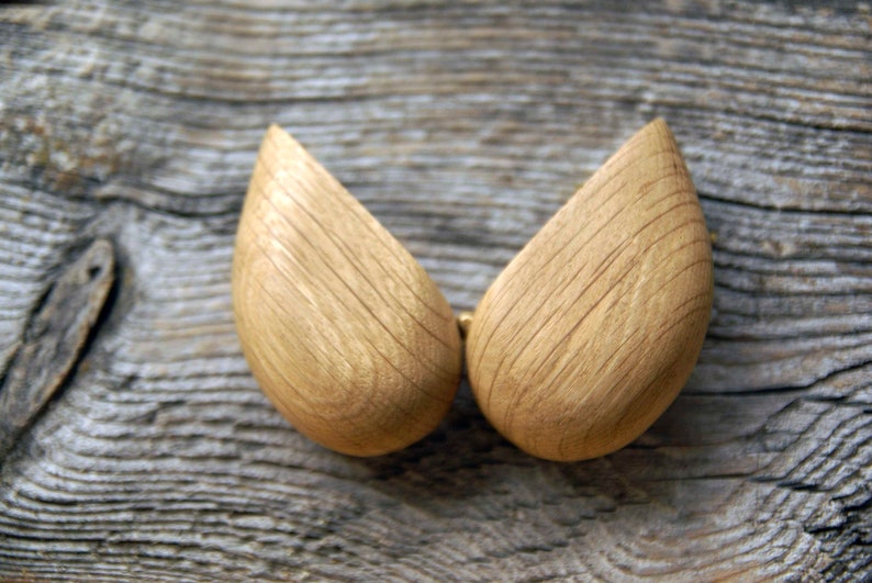 May include: Two wooden halves of a heart-shaped box, with a natural wood grain finish. The box is open and the two halves are separated.