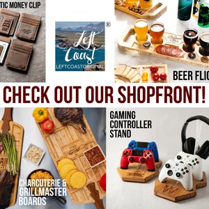 Puede incluir: Un collage de varios productos vendidos por Left Coast Original, que incluyen un clip magn&eacute;tico para dinero, una tabla para charcuter&iacute;a y asador, un juego de vuelo de cerveza y un soporte para mando de juego. El texto "CHECK OUT OUR SHOPFRONT!" se muestra en rojo.