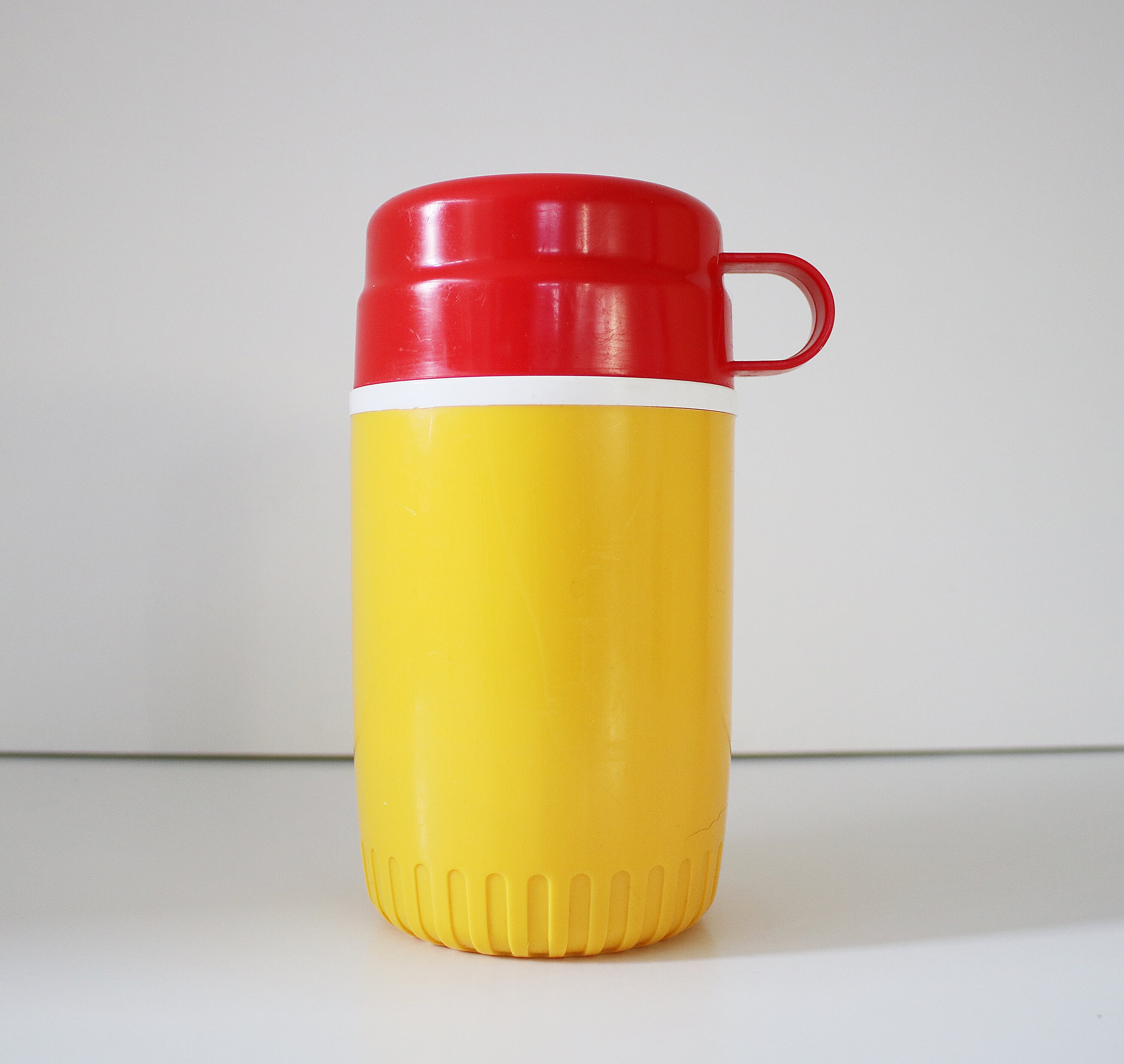 1980s flask by Bluebird Toys in bright yellow and red plastic