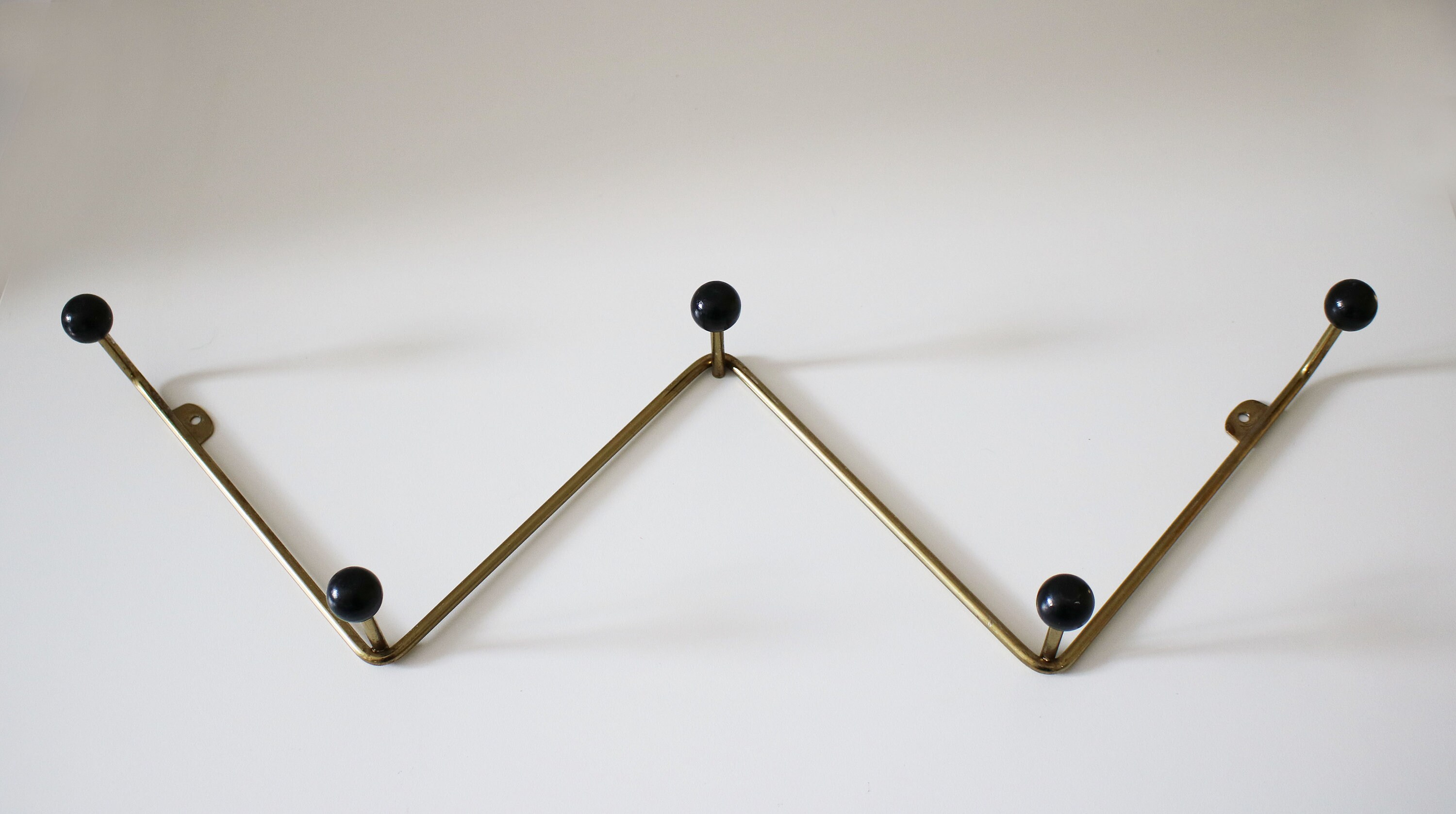 Atomic zigzag coat rack in gilt finish with black wooden bobbles