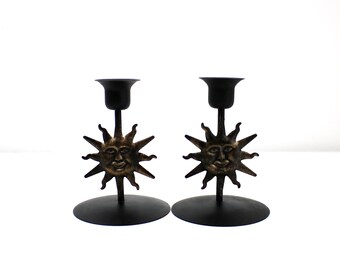 Pair of 1990s black metal candlesticks with bronze effect sun motif