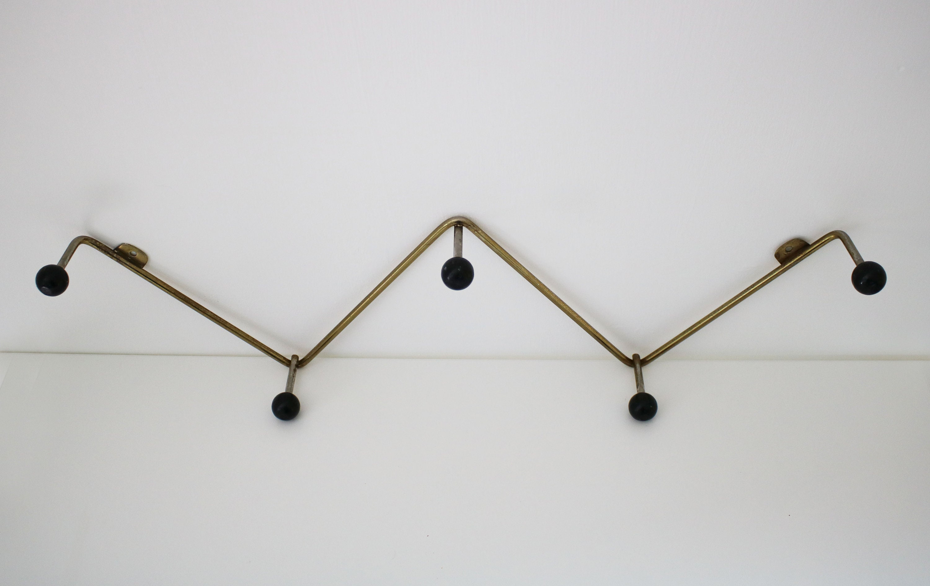 Atomic zigzag coat rack in gilt finish with black wooden bobbles