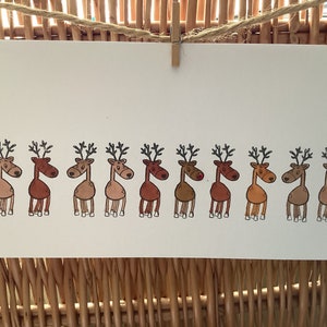 Handgemaakte kerstkaart rij rendieren