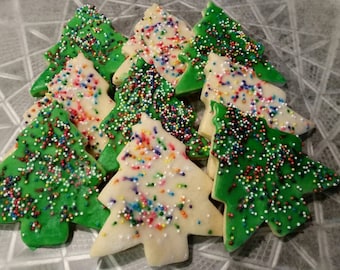 May include: A plate of green and white Christmas tree-shaped cookies decorated with colorful sprinkles.