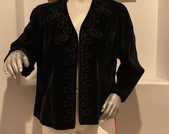 May include: A black velvet jacket with a V-neck and intricate embroidered detailing. The embroidery features a repeating pattern of swirls and beads.