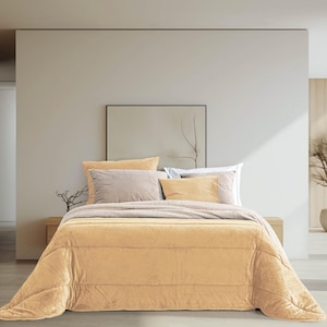 Può includere: Un letto con un piumino e cuscini color senape. Il letto è fatto con un copriletto e cuscini dai toni neutri. La stanza ha pareti colorate chiare e accenti in legno. Un'opera d'arte incorniciata è appesa sopra il letto.