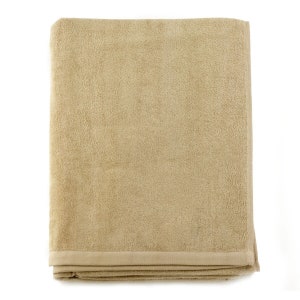 May include: A folded beige bath towel with a textured surface.