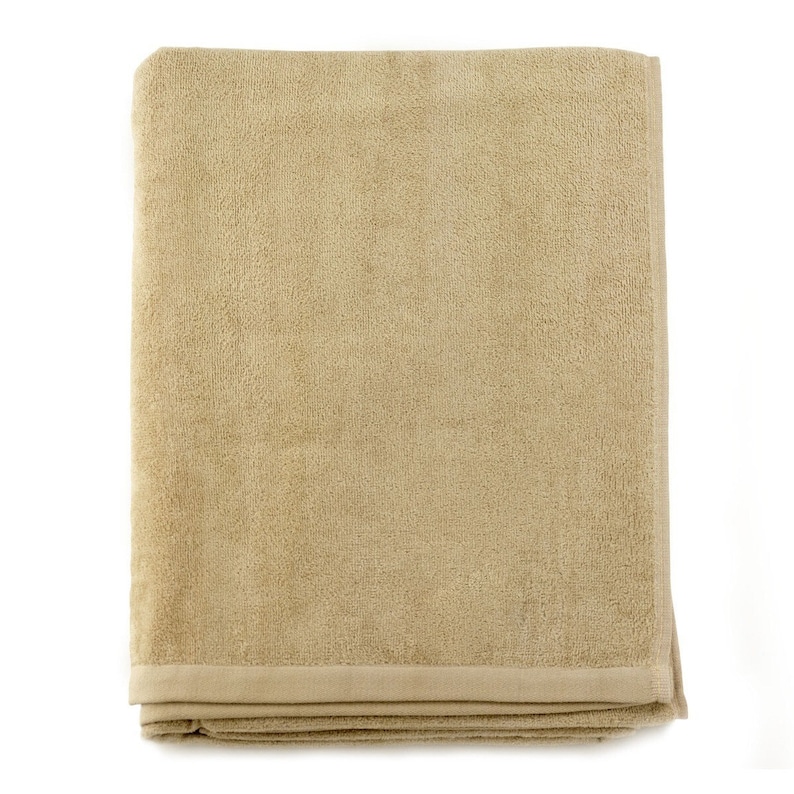 May include: A folded beige bath towel with a textured surface.