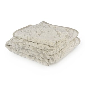 May include: A stack of two beige towels with a floral damask pattern. The towels are folded and have a soft, plush texture.