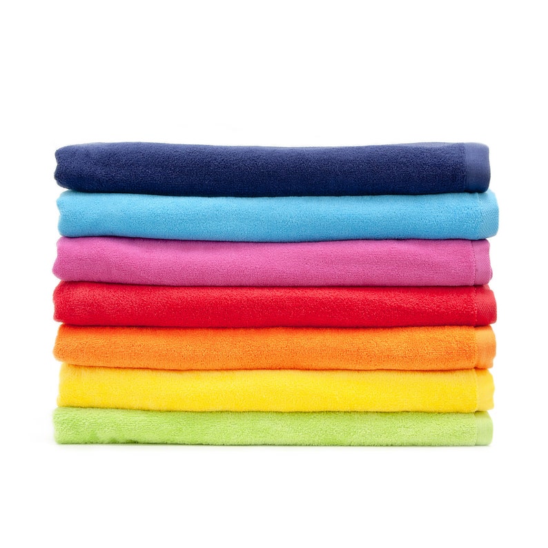 May include: A stack of seven colorful towels in a rainbow pattern. The towels are folded and stacked on top of each other. The colors of the towels are blue, light blue, pink, red, orange, yellow, and green.