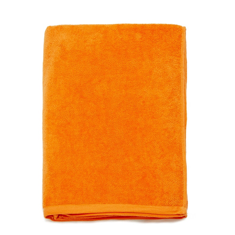 May include: A bright orange beach towel made of soft terry cloth. The towel is folded in half and is ready for use.