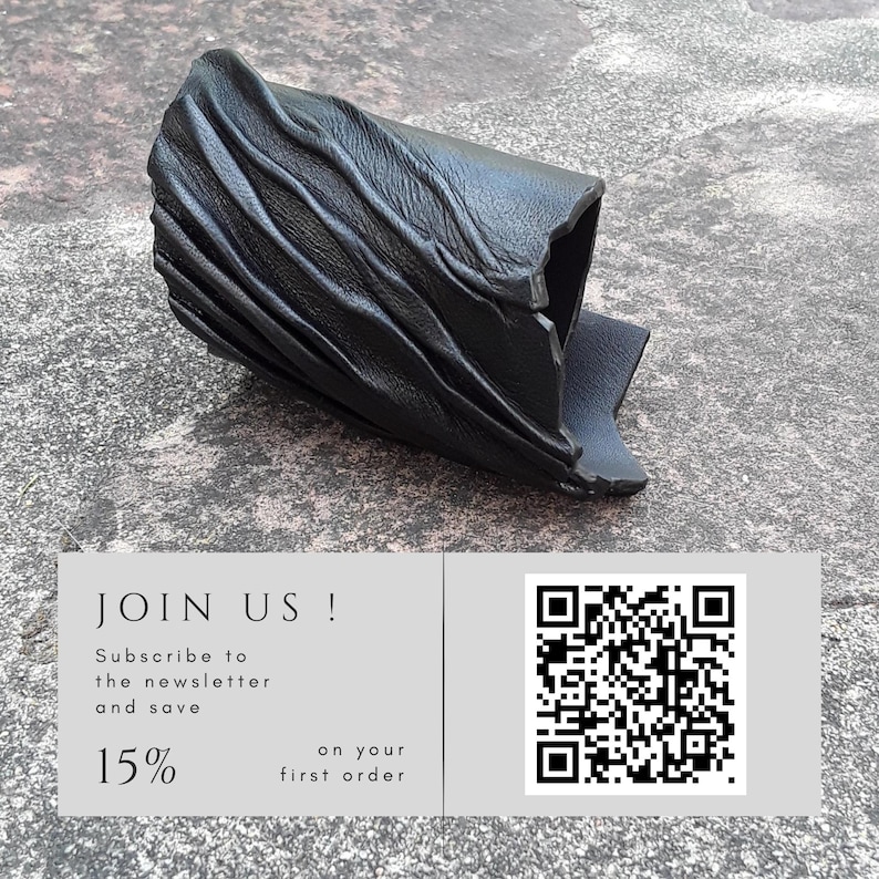 Puede incluir: Un brazalete de cuero negro que presenta una serie de crestas diagonales elevadas en su superficie. Debajo del brazalete hay un gr&aacute;fico rectangular que contiene el texto JOIN US! Subscribe to the newsletter and save 15% on your first order, junto a un c&oacute;digo QR.