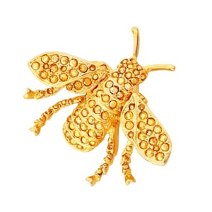 May include: A gold bee brooch with a detailed design of small, sparkling rhinestones.