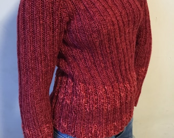 May include: A red knitted sweater with a ribbed texture. The sweater has long sleeves and a round neckline.