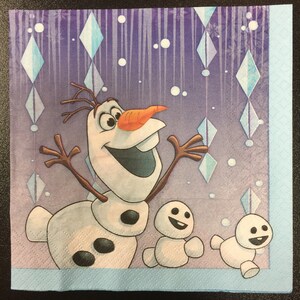 Puede incluir: Una servilleta de papel morada y azul con una imagen de dibujos animados de Olaf, el mu&ntilde;eco de nieve de la pel&iacute;cula Frozen, con dos mu&ntilde;ecos de nieve m&aacute;s peque&ntilde;os. El fondo tiene un patr&oacute;n de copos de nieve y cristales de hielo.