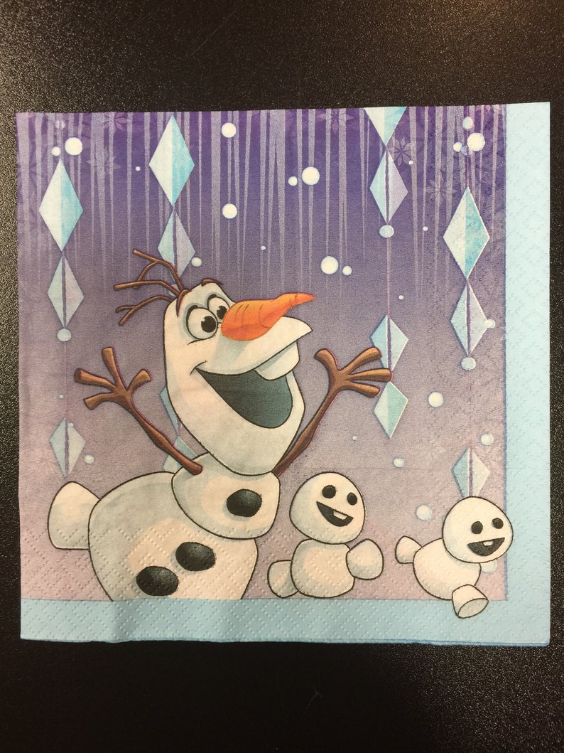 Puede incluir: Una servilleta de papel morada y azul con una imagen de dibujos animados de Olaf, el mu&ntilde;eco de nieve de la pel&iacute;cula Frozen, con dos mu&ntilde;ecos de nieve m&aacute;s peque&ntilde;os. El fondo tiene un patr&oacute;n de copos de nieve y cristales de hielo.
