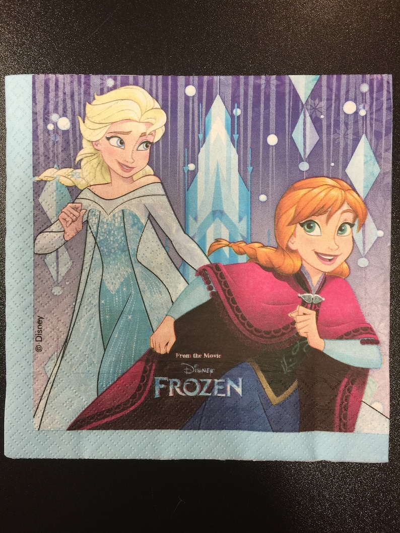 Puede incluir: Una servilleta de papel azul y morada con una imagen de Elsa y Anna de la pel&iacute;cula de Disney Frozen. El texto "From the Movie Disney Frozen" est&aacute; impreso en la servilleta.