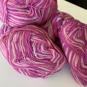 May include: Two balls of pink and white striped yarn.