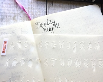 Cursive Letters Bullet Journaling Stencil ajoute des lettres fantaisie à vos mises en page bujo. Obtenez-le ici.