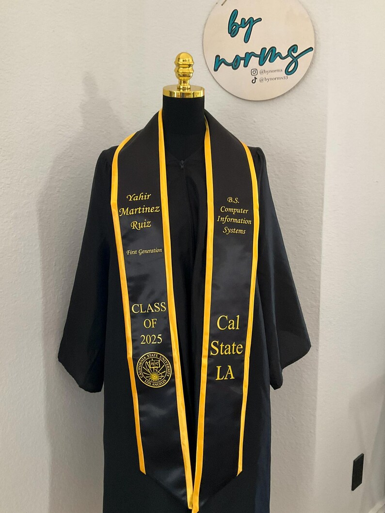 May include: Black graduation stole with gold trim and the text "Yahir Martinez Ruiz, First Generation, B.S. Computer Information Systems, Class of 2025, Cal State LA" and a California State University Los Angeles seal.